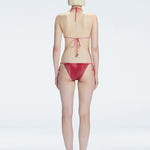 Back view of model wearing Hermione Red Optical Bikini Bottom, highlighting the low-waist fit and sleek design.
