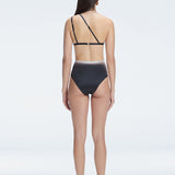 Back view of model wearing Eva Black Optical Bikini Top, highlighting the elegant one-shoulder design.
