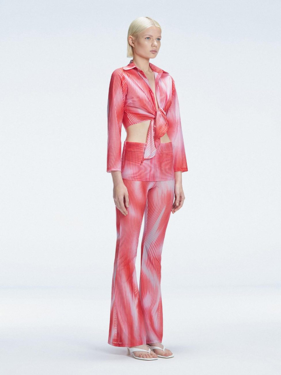 Side view of model showcasing the front tie and sleek fit of the Greta Red Sonar Top and Freya Pant
