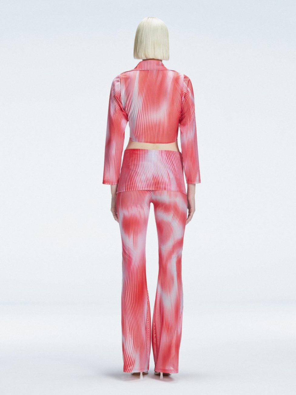Back view of model wearing Greta Red Sonar Top, highlighting the long sleeves and printed mesh fabric.
