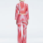 Back view of model wearing Greta Red Sonar Top, highlighting the long sleeves and printed mesh fabric.
