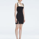 Side view of model showcasing the chic buckle accents and front slit on the Heather Black Mini Dress.
