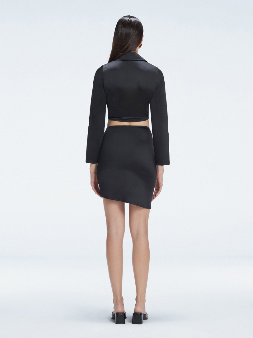 Back view of model wearing Greta Black Shirt and Antonia Black Skirt, highlighting the slim fit and sleek swimwear fabric.
