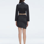 Back view of model wearing Greta Black Shirt and Antonia Black Skirt, highlighting the slim fit and sleek swimwear fabric.
