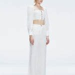 Side view of model showcasing the wide-leg design and sleek silhouette of the Valencia White Pants.
