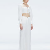 Side view of model showcasing the wide-leg design and sleek silhouette of the Valencia White Pants.
