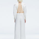 Back view of model wearing Valencia White Pants, highlighting the crisscross back straps and high-waisted fit.
