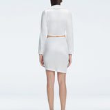 Back view of model wearing Greta White Shirt and Antonia White Skirt, highlighting the elegant cropped silhouette.
