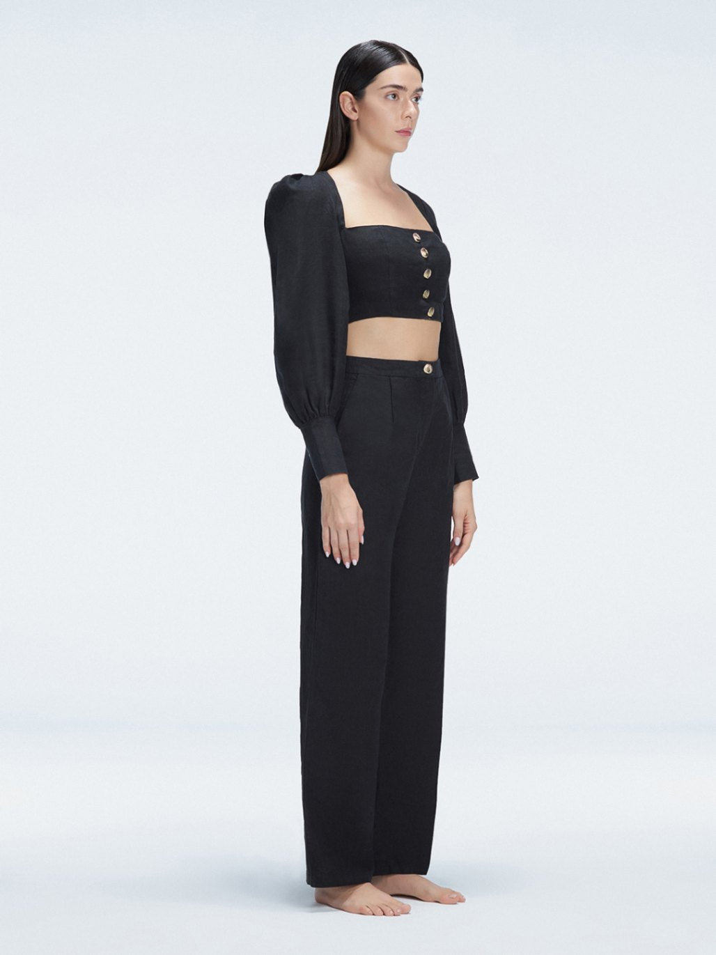 Side view of model showcasing the wide-leg design and sleek silhouette of the Gemma Black Cropped Top and Valencia Black Pants.