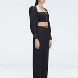 Side view of model showcasing the crisscross back detail on the Gemma Black Cropped Top.
