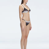 Side view of model showcasing the low-rise design and side ties on the Rory Black Bikini Bottom.
