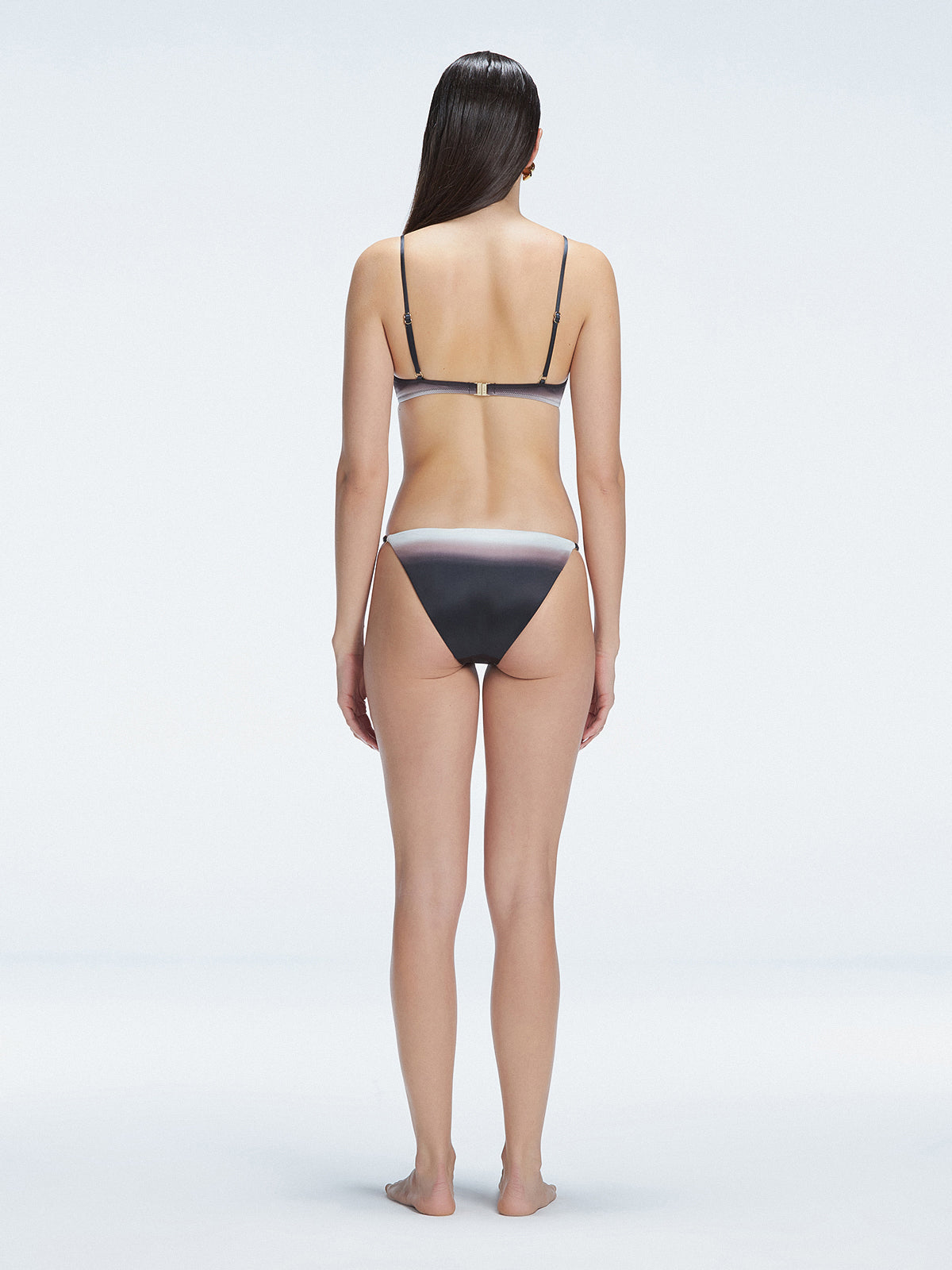 Back view of model wearing Rory Black Optical Bikini Top, highlighting the halterneck design and sleek fit.
