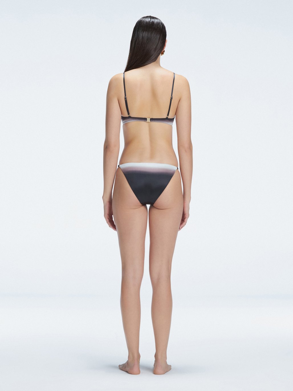 Back view of model wearing Rory Black Optical Bikini Bottom, highlighting the low bottom coverage and sleek fit.

