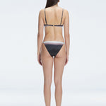Back view of model wearing Rory Black Optical Bikini Bottom, highlighting the low bottom coverage and sleek fit.
