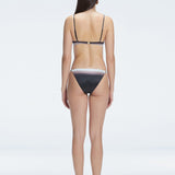 Back view of model wearing Rory Black Optical Bikini Bottom, highlighting the low bottom coverage and sleek fit.
