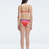 Back view of model wearing Rory Pink Optical Bikini Top, highlighting the halterneck design and sleek fit.
