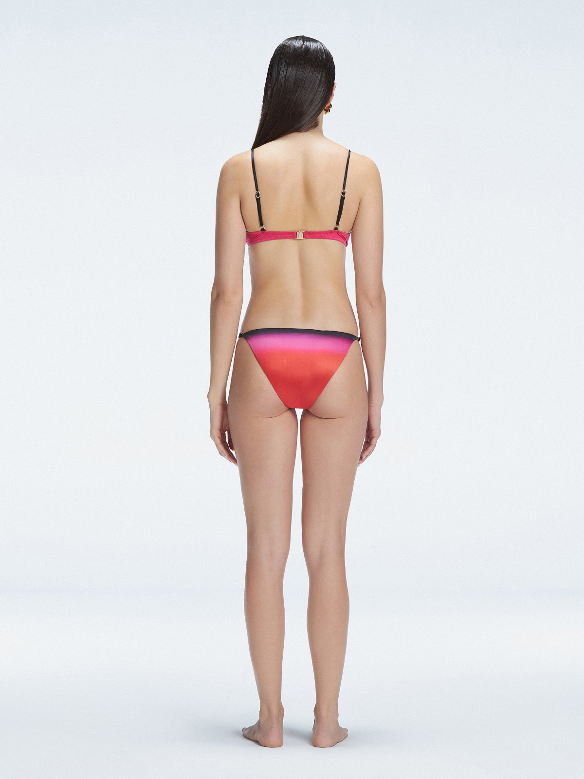 Back view of model wearing Rory Pink Optical Bikini Top, highlighting the halterneck design and sleek fit.
