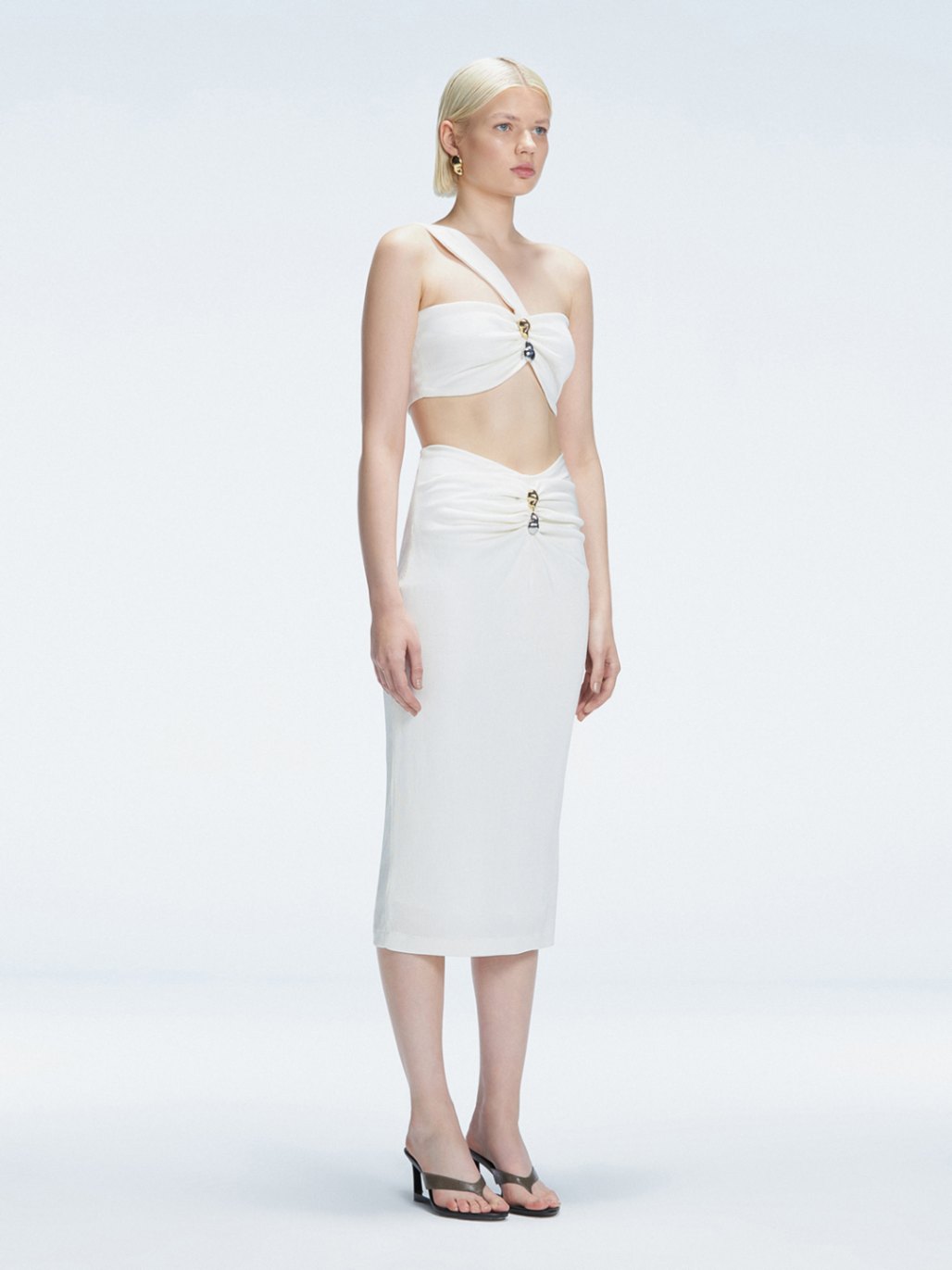 Side view of model showcasing the ruched front and sleek silhouette of the Lane Top and Esmeralda White Midi Skirt.
