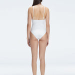 Back view of model wearing Marina Degraded White One Piece swimsuit, featuring accessory details on straps and open back design.
