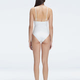 Back view of model wearing Marina Degraded White One Piece swimsuit, featuring accessory details on straps and open back design.
