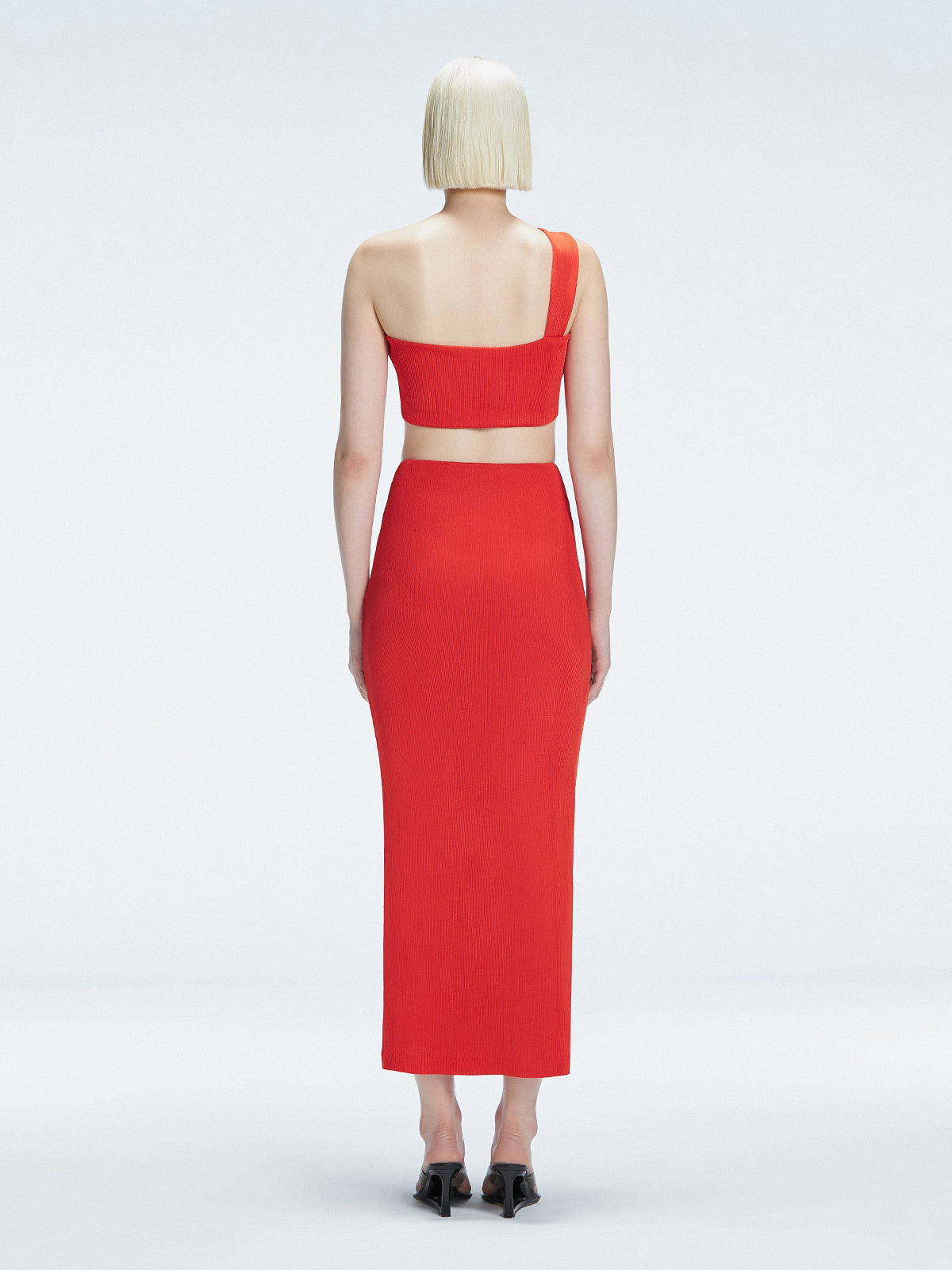 Back view of model wearing Lane Red Top, highlighting the sleek one-shoulder silhouette.
