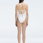 "Model showing the back of the Emma White Swimsuit, highlighting the sleek fit and moderate coverage."
