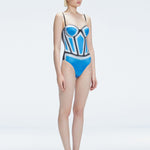 Side view of model showcasing the printed fabric and removable straps on the Camilla Blue Swimsuit.
