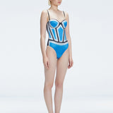 Side view of model showcasing the printed fabric and removable straps on the Camilla Blue Swimsuit.
