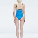 Back view of model wearing Camilla BlueOptical Swimsuit, highlighting the sleek fit and moderate coverage.
