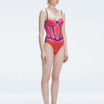 Side view of model showcasing the printed fabric and removable straps on the Camilla Red Swimsuit.
