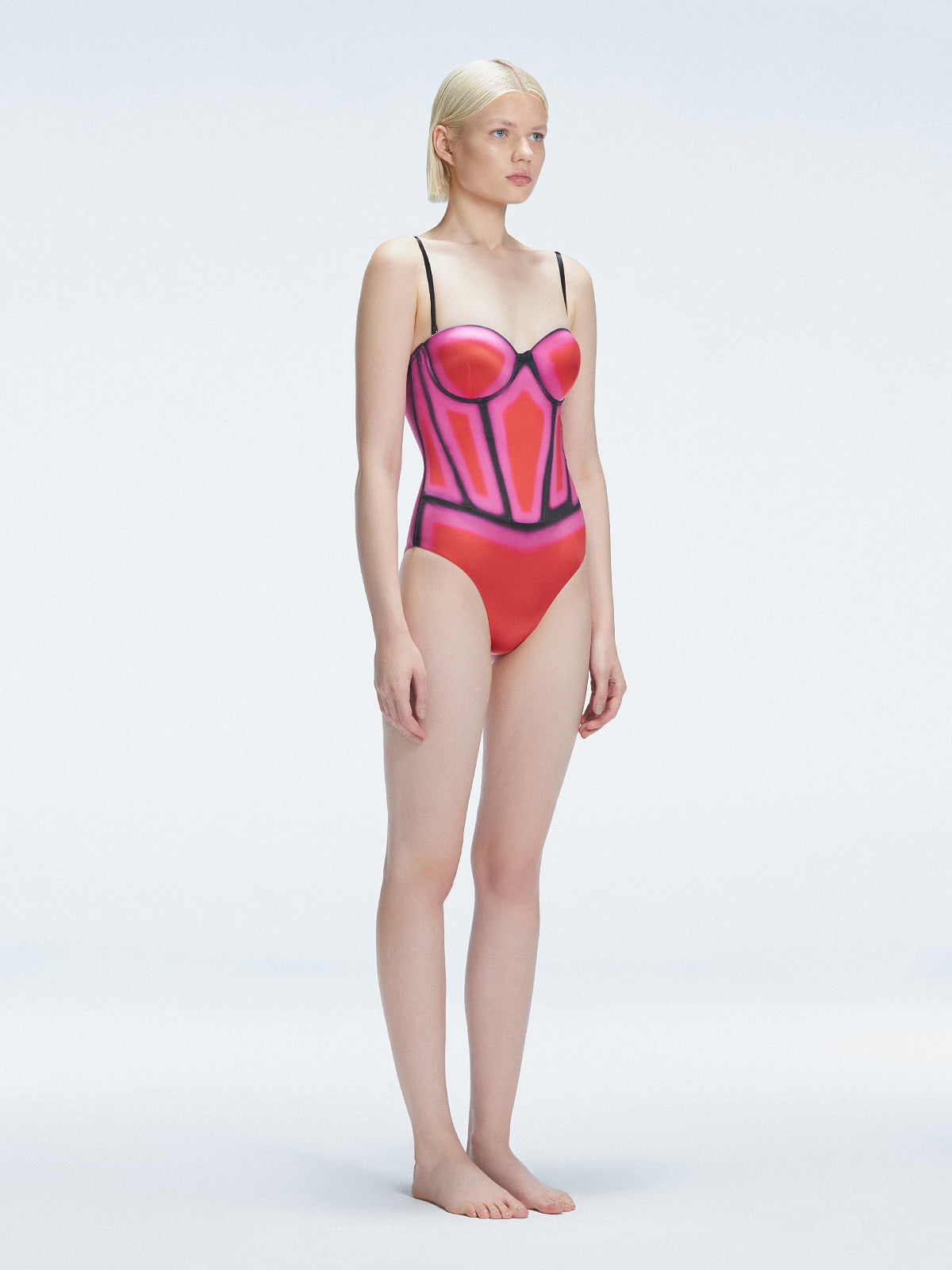 Side view of model showcasing the printed fabric and removable straps on the Camilla Red Swimsuit.
