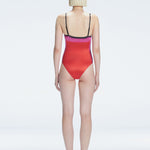 Back view of model wearing Camilla Pink Optical Swimsuit, highlighting the sleek fit and moderate coverage.
