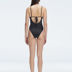 "Model showing the back of the Emma Black Swimsuit, highlighting the sleek fit and moderate coverage."
