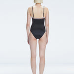 Back view of model wearing Camilla Black Optical Swimsuit, highlighting the sleek fit and moderate coverage.
