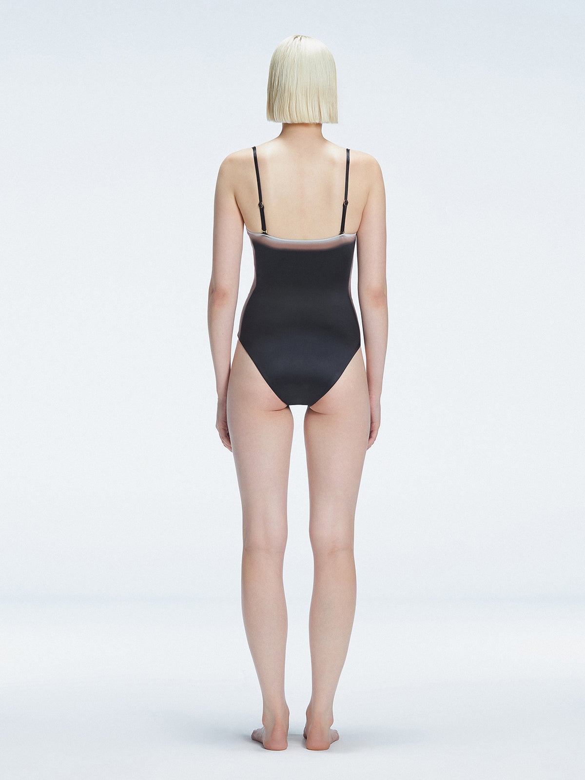 Back view of model wearing Camilla Black Optical Swimsuit, highlighting the sleek fit and moderate coverage.
