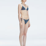 Side view of model showcasing the side ties and low bottom coverage on the Hermione Black  Bikini Bottom.

