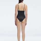 Back view of model wearing Marina Degraded Black One Piece swimsuit, featuring accessory details on straps and open back design.
