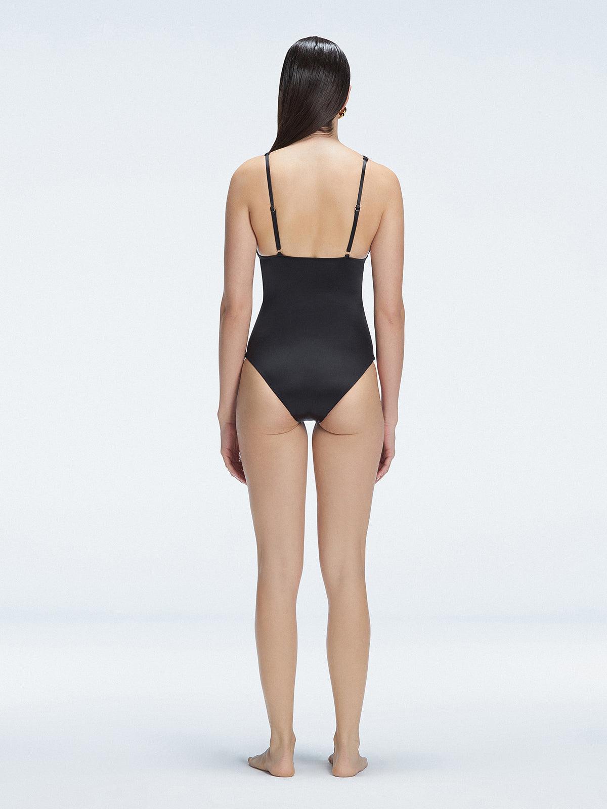 Back view of model wearing Marina Degraded Black One Piece swimsuit, featuring accessory details on straps and open back design.
