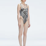 Side view of model showcasing the printed tulle and scoop neck on the Calista Black Swimsuit.
