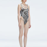 Side view of model showcasing the printed tulle and scoop neck on the Calista Black Swimsuit.
