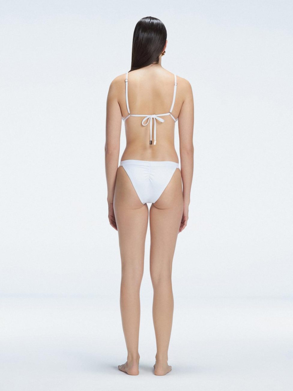 "Back view of the buckle and low waist design on the Zella White Bikini Bottom, emphasizing the fresh and trendy style."
