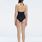 Back view of model wearing Miley Black One Piece swimsuit, highlighting the tie closure and full bottom coverage.
