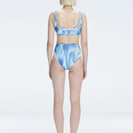 Back view of model wearing Rosalind Blue Optical Bikini Bottom, highlighting the high-waisted fit and full coverage.
