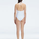 Back view of model wearing Miley White One Piece swimsuit, highlighting the tie closure and full bottom coverage.
