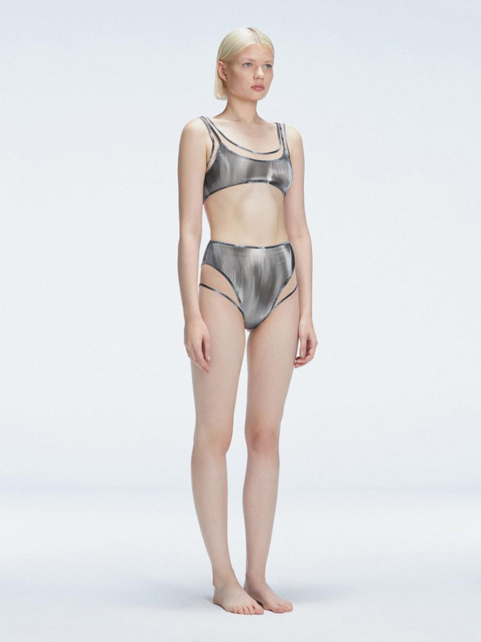 Side view of model showcasing the printed tulle and sleek high-waist fit on the Rosalind Black Bikini Set.

