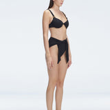 "Side view of the Dylan Black Bikini Bottom's fabric, showcasing the softness and durability of the Italian material."
