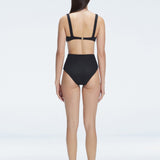 "Model showcasing the back of the Dylan Black Bikini Bottom, emphasizing the comfortable fit and moderate coverage."
