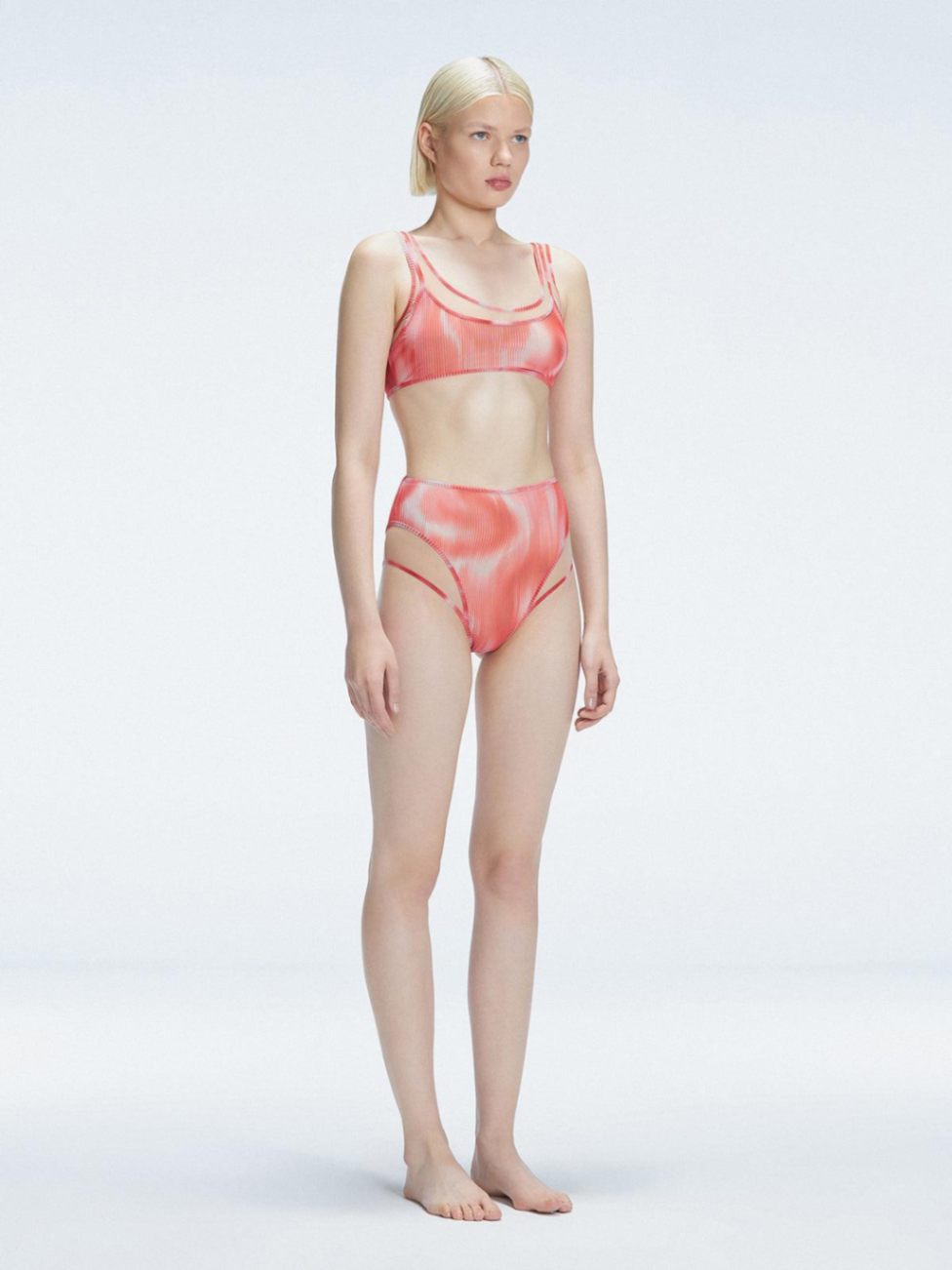 Side view of model showcasing the printed tulle and sleek high-waist fit on the Rosalind Red Bikini Set.
