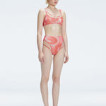 Side view of model showcasing the printed tulle and sleek high-waist fit on the Rosalind Red Bikini Bottom.
