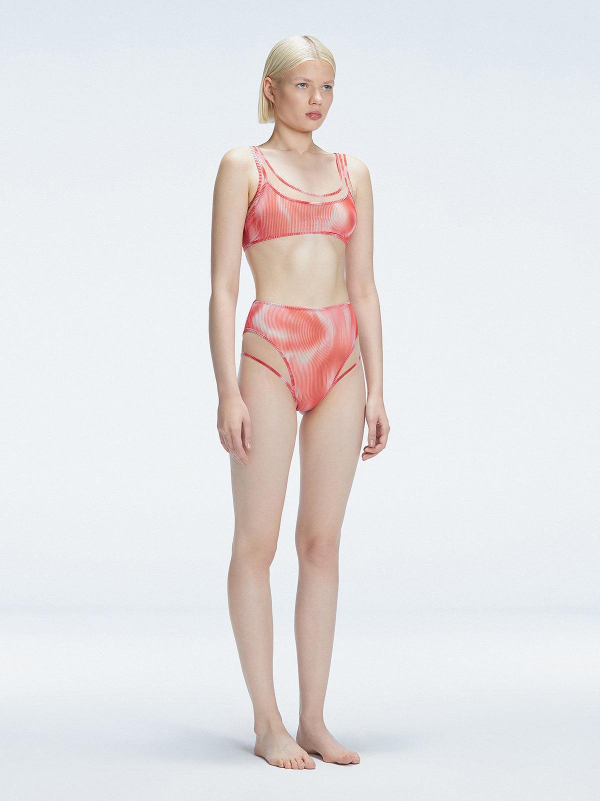 Side view of model showcasing the printed tulle and sleek high-waist fit on the Rosalind Red Bikini Bottom.
